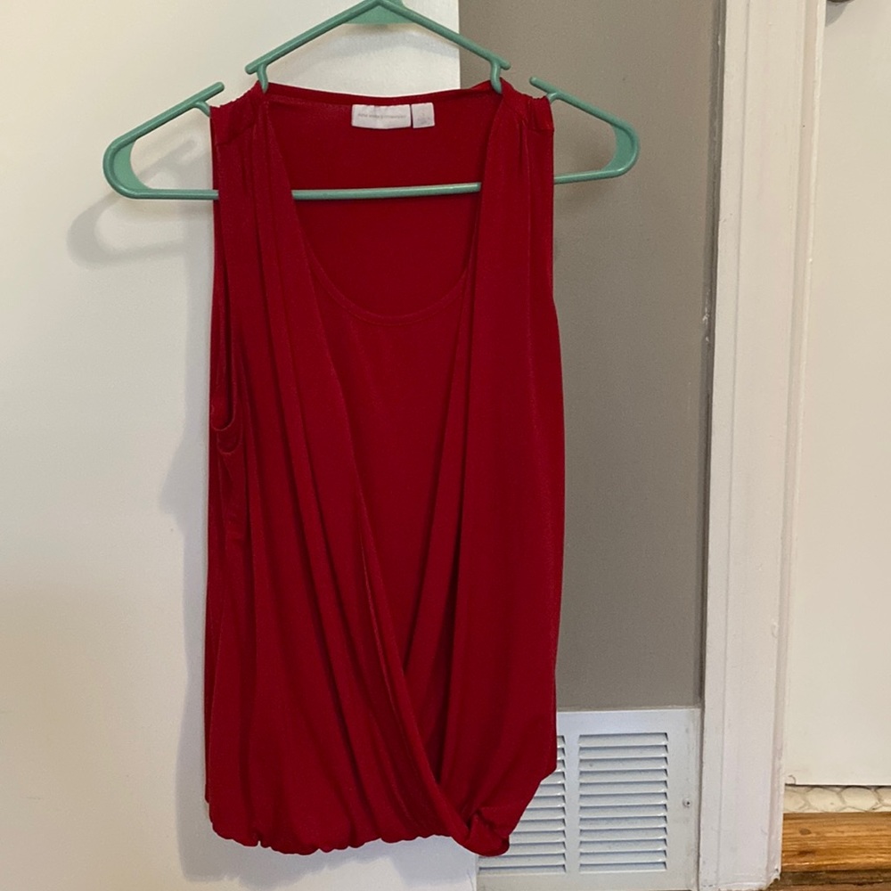 Sleeveless red blouse.